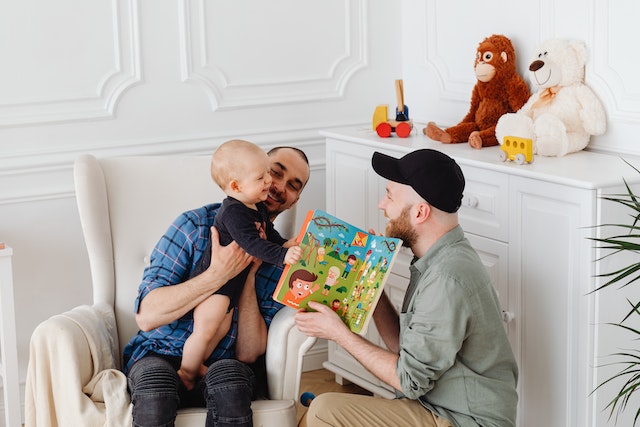 a family reading a book to their baby